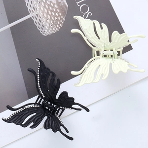 Close-up of matte butterfly hair clips with sparkling rhinestones and spring clamp detail