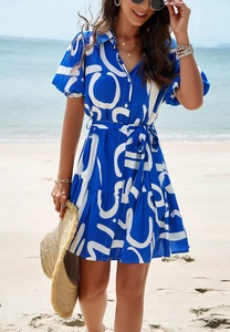 Close-up of blue and white geometric print dress with front buttons and ruffled hemline