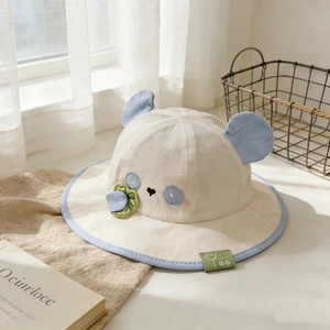 Dettaglio cappello sole neonato a forma di panda con orecchie blu, ricami e piccolo fiore