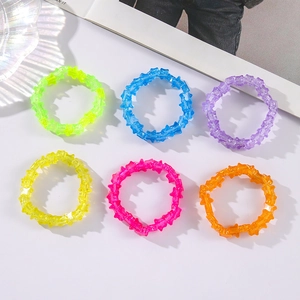 Detail of six colorful star-shaped acrylic elastic bracelets in vibrant neon shades