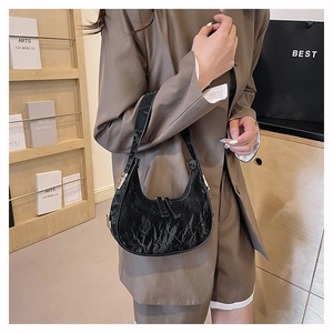 Close-up of the crinkled texture and silver zipper detail on the black hobo bag