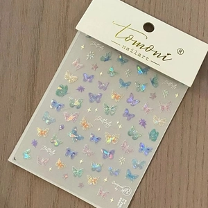 Holographic butterfly nail art stickers with laser finish on light wood background