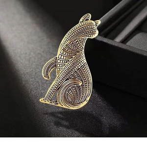 Vintage gold abstract cat brooch featuring geometric patterns on a textured black base