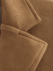 Gros plan du col d'un blazer en daim camel avec des coutures et une texture de qualité