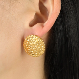French retro round disc earrings with woven texture in 18k gold on earlobe