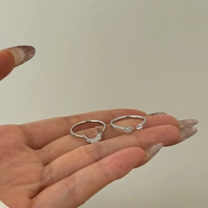 Detail of silver S925 moon and star rings with sparkling zircons on female hand