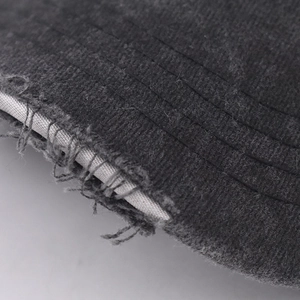 Macro view of distressed frayed edges and parallel stitching on a grey baseball cap