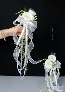Macro shot of wedding glass decor with white faux roses, pearls and organza ribbons