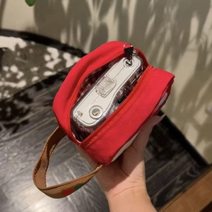 Red canvas camera bag with apple embroidery and checkered lining featuring wrist strap
