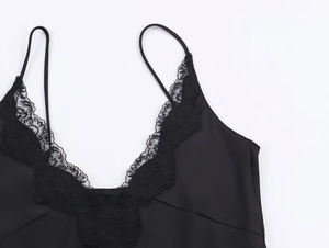 Close-up of black silk-textured camisole featuring intricate lace detailing at the V-neckline