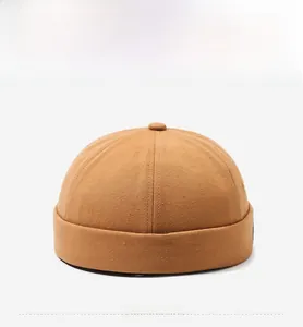 Front view of a brown canvas brimless docker cap with detailed stitching and top button