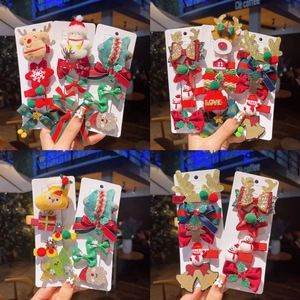 Detail showing a festive Christmas hair clip set with reindeer, Santa, and tree designs