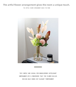 Nordic gold geometric metal vase with pink carnations on a grey book in a cozy setting