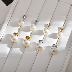Detailed view of vintage pearl stud earrings with crystal settings on a textured display