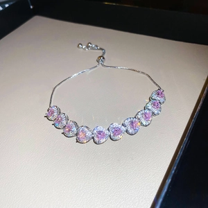 Detail of pink heart zircon bracelet with silver adjustable chain on leather background