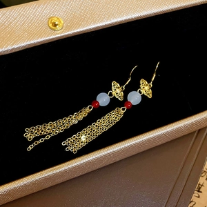 Elegant gold butterfly cloud fringe earrings with blue beads in a velvet jewelry box
