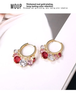 Detailed macro view of gold-plated earring hoops featuring vibrant faceted gemstone charms