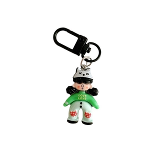 Cute cartoon girl keychain with blue pants and cat ear hat on a white background