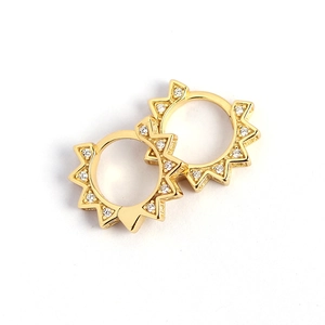Gold sunburst hoop earrings with sparkling crystal accents in punk gear style for women