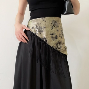 Detail of gold floral brocade waist belt with elegant long black fringe tassels