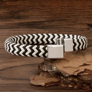 Close-up of black and white braided leather bracelet with silver magnetic alloy clasp