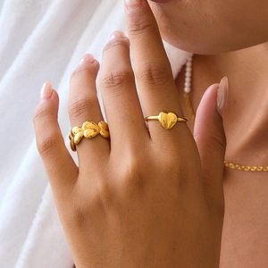 Elegant gold heart-shaped stainless steel rings set displayed on a model's hand