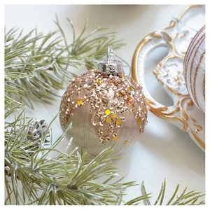 Nahaufnahme der champagnerfarbenen Weihnachtskugel mit Pailletten auf Tannenzweigen
