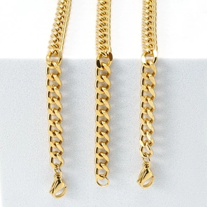 Three rows of gold 18K stainless steel Cuban link necklaces with lobster clasps on white