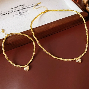 Detail of gold heart necklace and bracelet set with faceted beads and lobster clasp