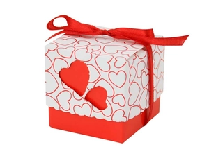 Detail of red and white wedding favor box with double heart cut-outs and a red ribbon bow