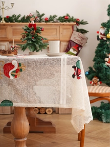 Detail of Christmas table runner with festive Santa Claus embroidery and lace texture