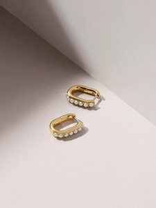 Detail of 18K gold U-shaped earrings with faux pearl row on textured minimalist base