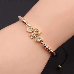 Close-up of woven bracelet featuring tri-color beads and zircon heart pendants on wrist