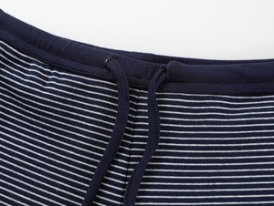 Détail de la taille en maille bleu marine à rayures blanches et cordon en coton