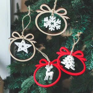 Wooden Christmas pendants with snowflake deer star and tree shapes hanging on a tree