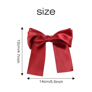 Detail view of red satin bow hair clip measuring 14cm by 12cm with smooth texture