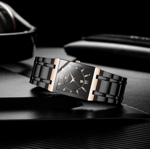 Detail of square business watch with black dial, Roman numerals, and two-tone steel strap