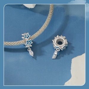 Detail of S925 silver blue enamel flower charm with marquise crystal on a mesh bracelet