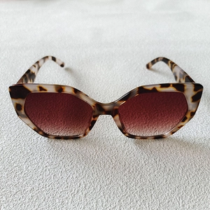 Detail of tortoise shell frame sunglasses with brown gradient lenses and cat-eye shape