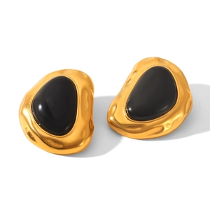 Detail of irregular 18k gold plated earrings with black resin and hammered texture