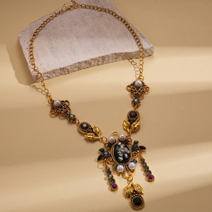 Vintage gold Victorian style necklace with pearls and rhinestones on stone pedestal