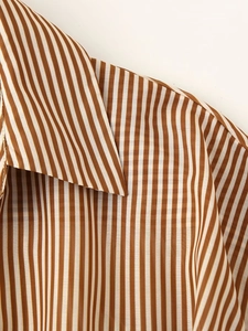 Close-up of the shirt collar showing brown and white vertical stripes and fabric texture