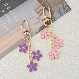 Close-up of colorful enamel flower charms for handbags and keys in purple and pink