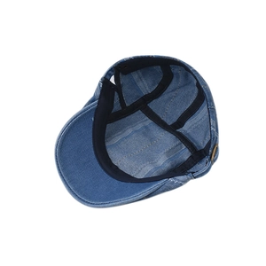 Detail of light blue denim flat cap interior with black sweatband and reinforcement