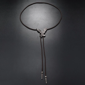 Close-up of eagle-shaped antique silver bolo tie with dark brown braided leather cord
