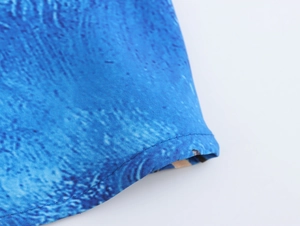 Dettaglio macro dell'orlo in tessuto blu testurizzato con cuciture e motivi sottili