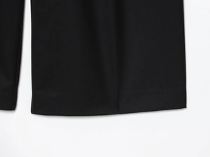 Detailed close-up showing the twill fabric texture and hem of these black trousers