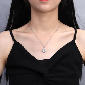 Close-up of a pear-shaped halo pendant necklace worn on a model's neck for elegant style