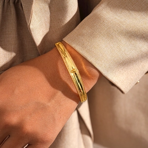 Detail of 18k gold plated bangle featuring zircon inlay and a vintage lion relief emblem