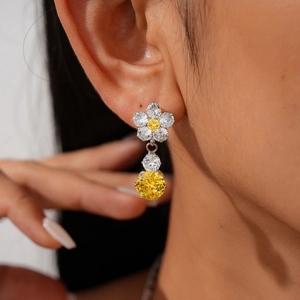 Close-up of elegant flower drop earrings featuring sparkling yellow and white zircon stones